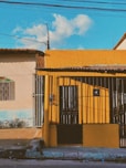 a yellow building with a gate