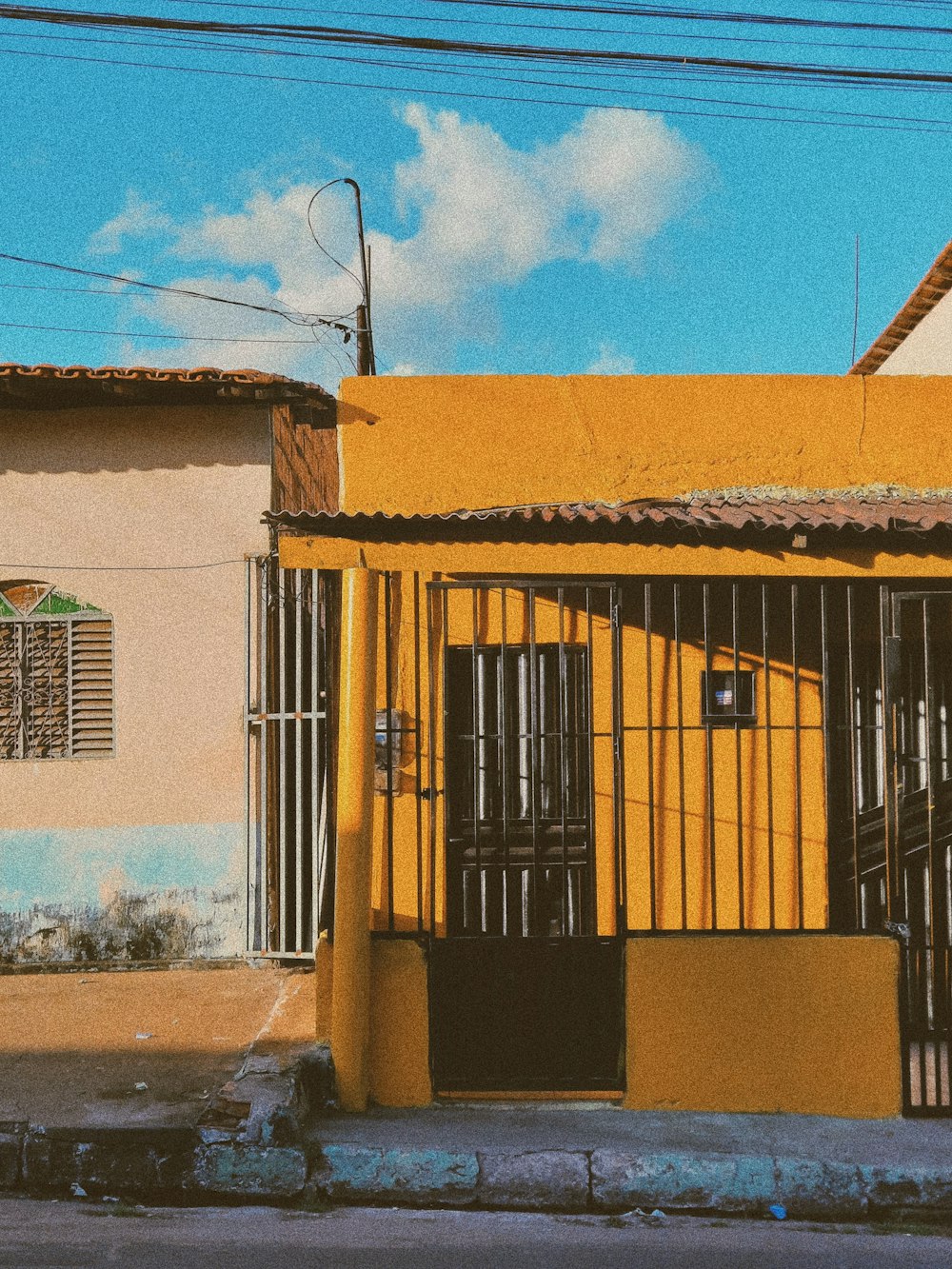 a yellow building with a gate