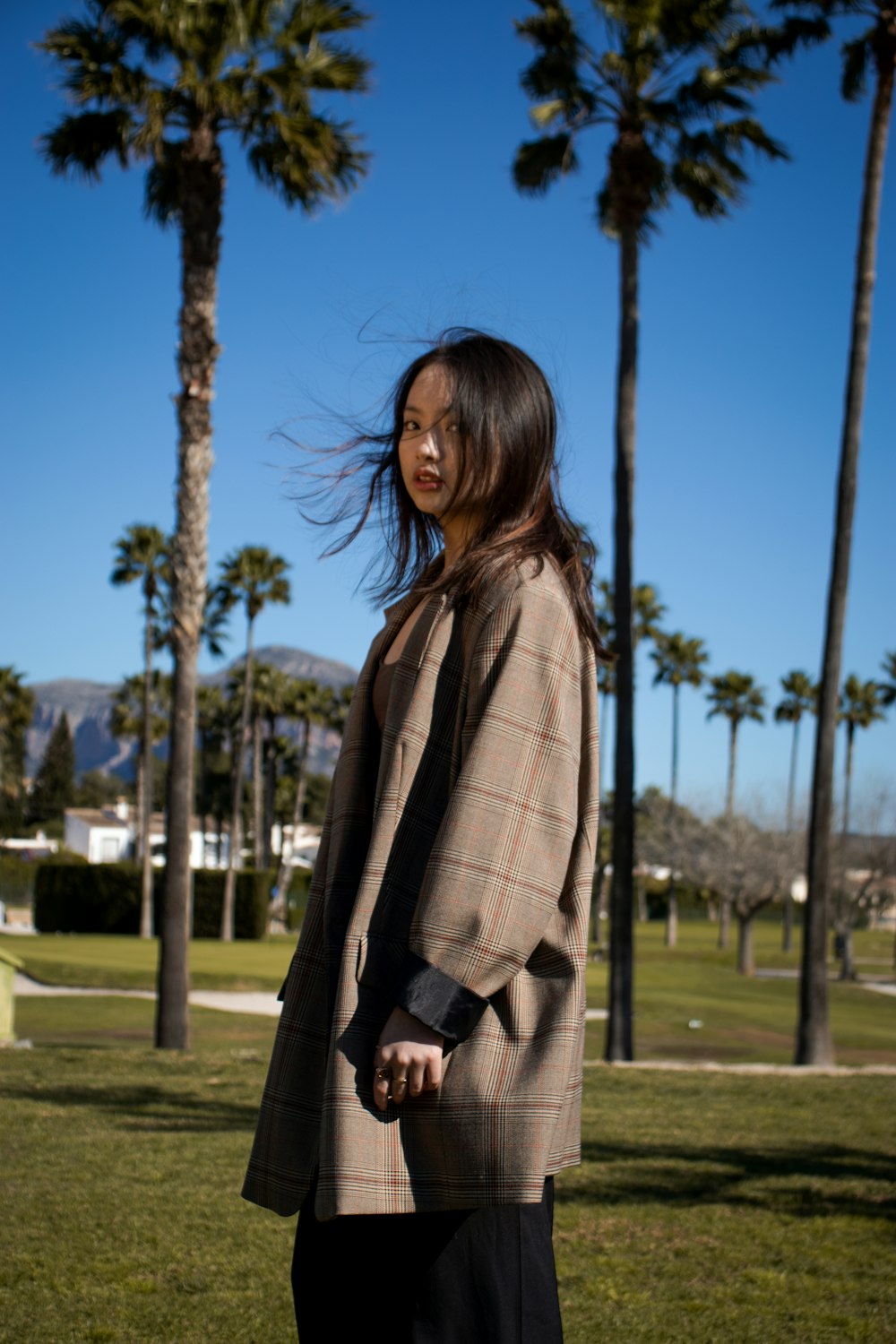 a person standing in a field with palm trees