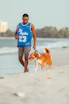 a man walking a dog on a beach