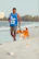 a man walking a dog on a beach