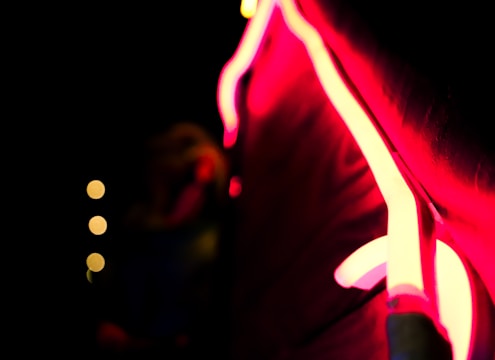 Blurred neon pink and blue card with pulsing warm LED-like lights glowing softly.