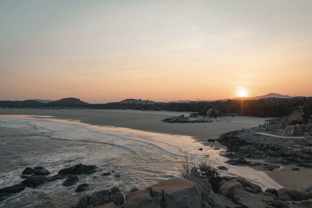 Una spiaggia innevata con un tramonto