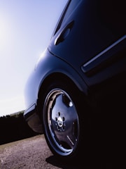 Close-up of a shiny, freshly detailed car wheel and tire under natural light