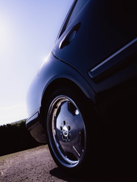 Close-up of a shiny, freshly detailed car wheel and tire under natural light