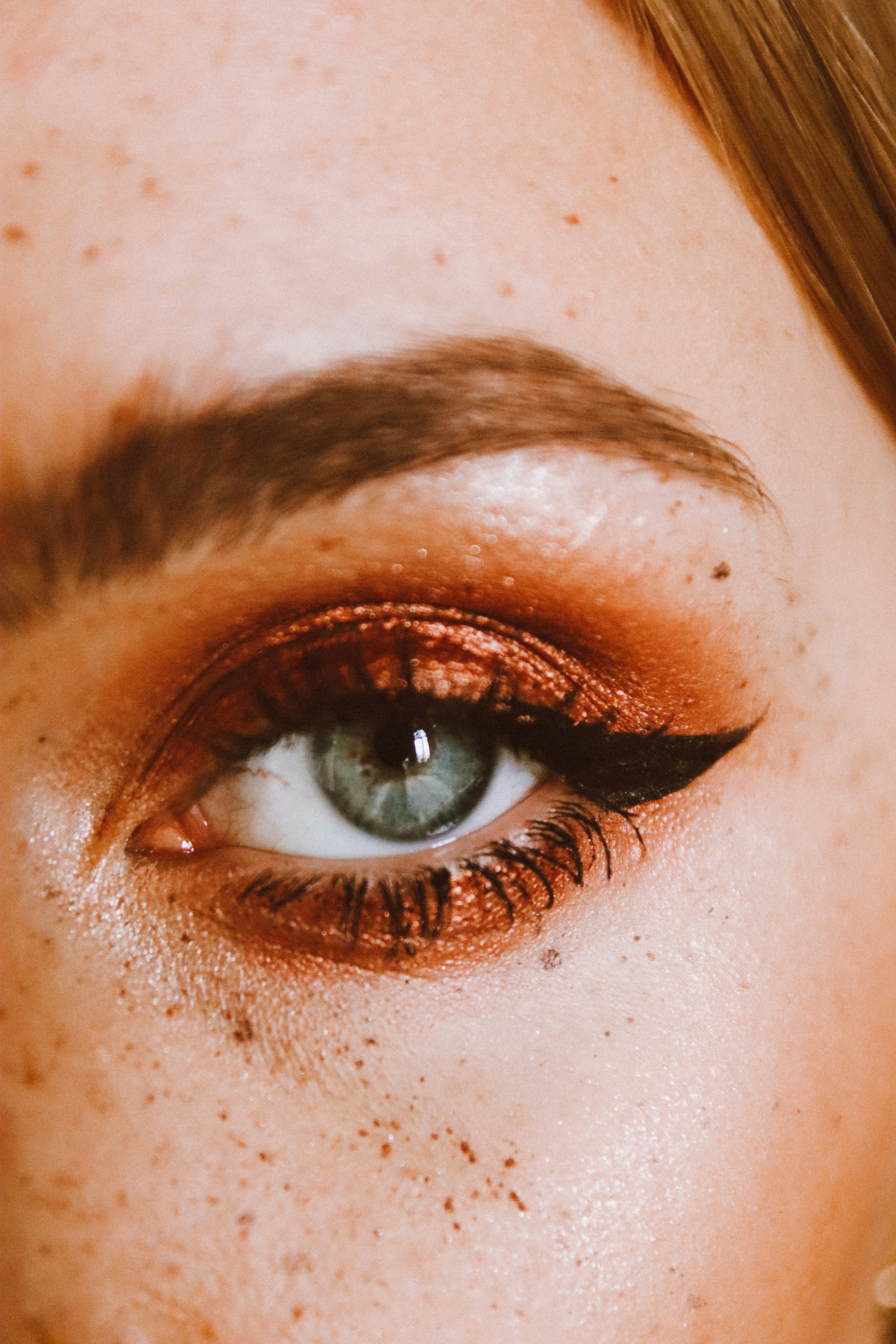 Model applying Ajan bronze eyeshadow palette