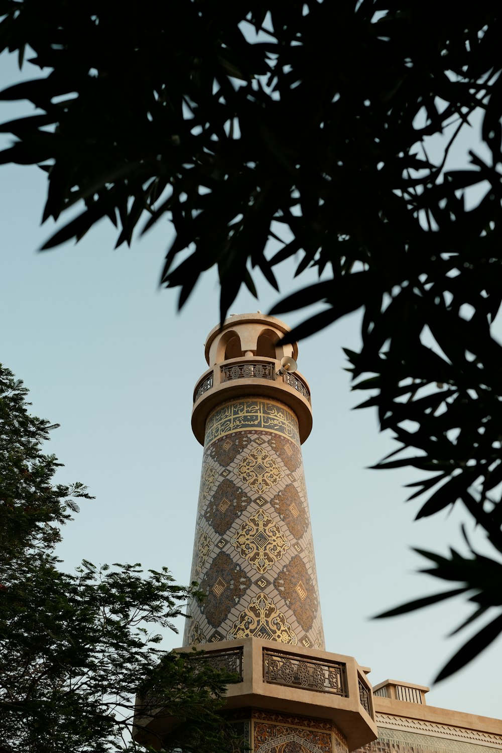 a tall clock tower sitting next to a tree