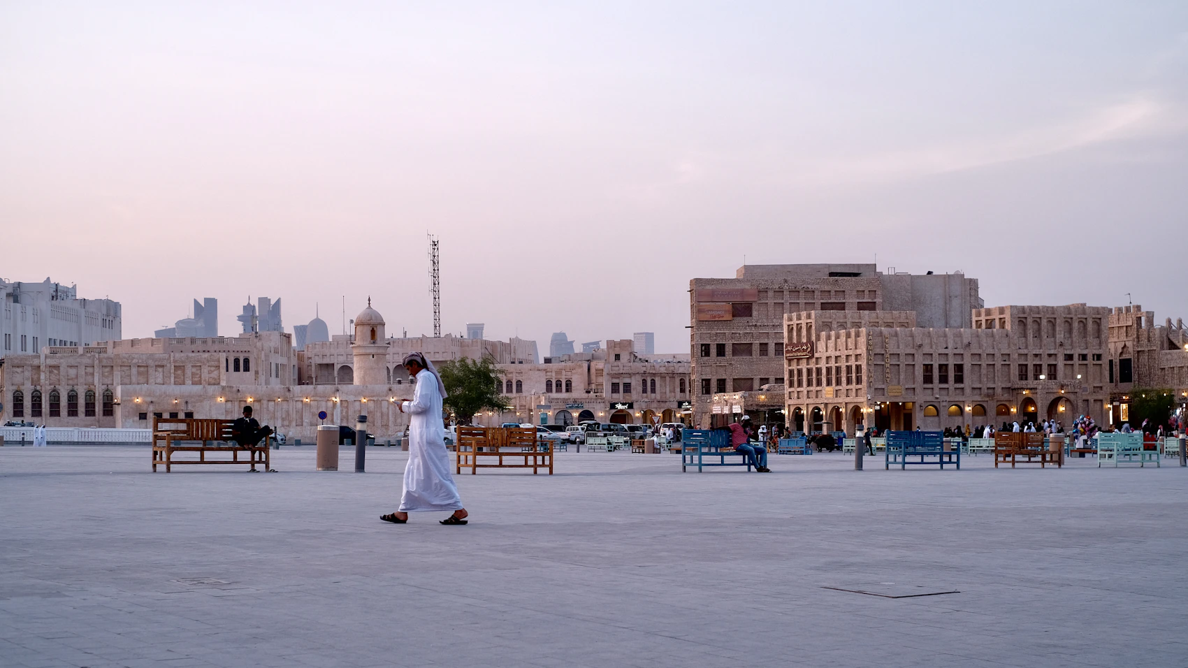 People crossing the open square at Souq Waqif in Doha at dusk