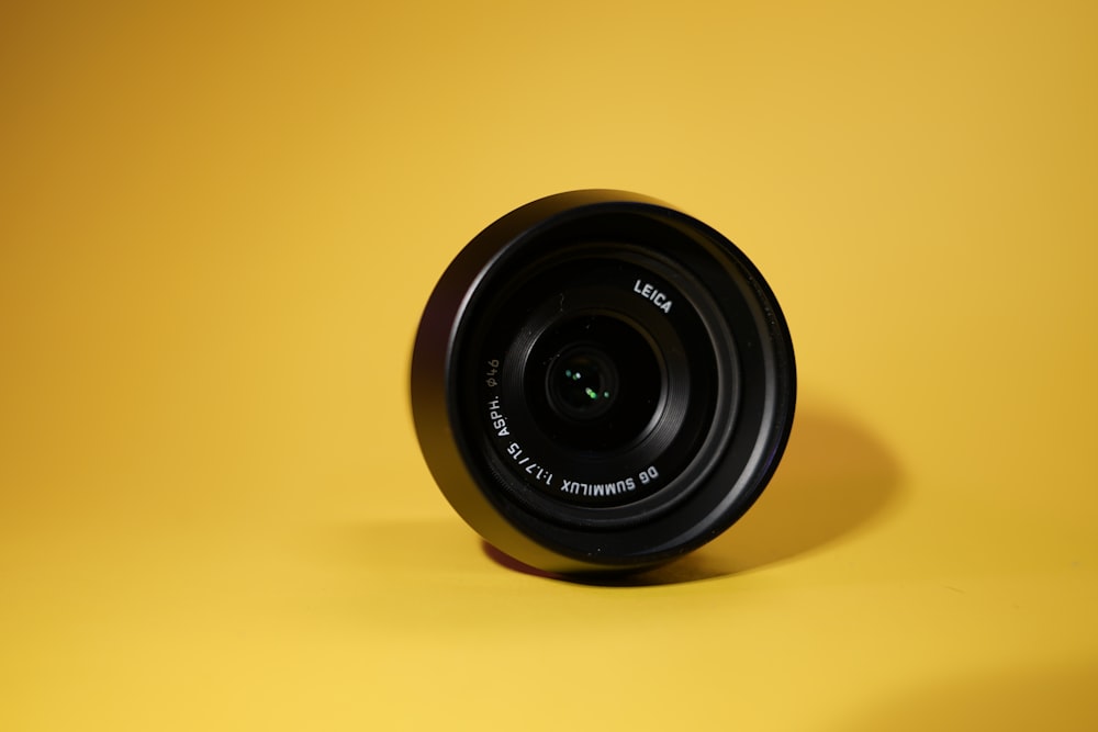 a camera lens on a yellow surface
