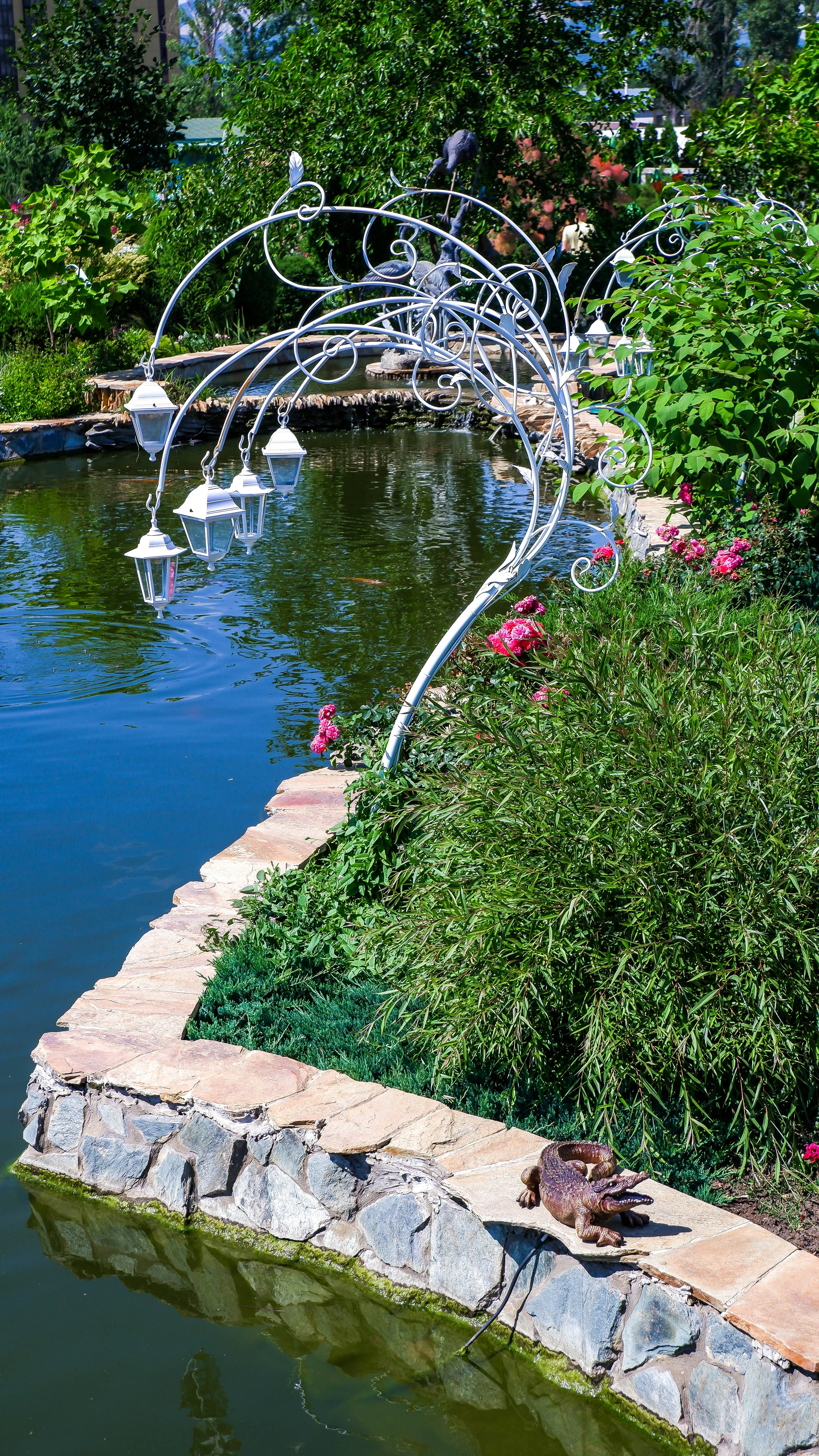 a small pond with a metal bridge