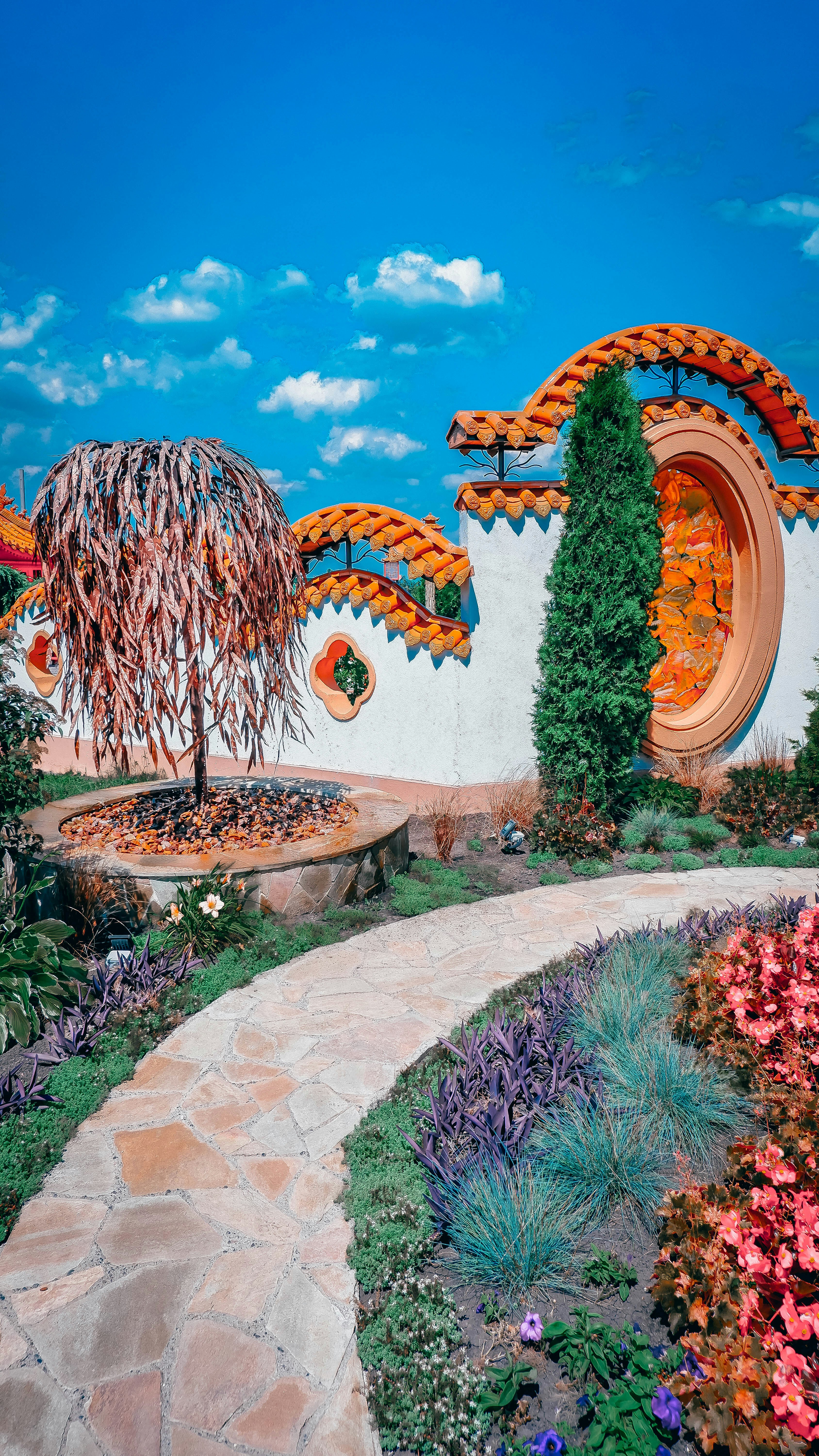a garden with a fountain and plants
