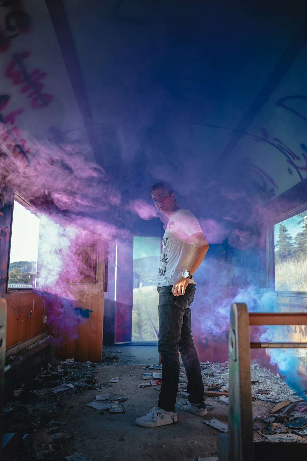 a man standing in a room with a wall of graffiti