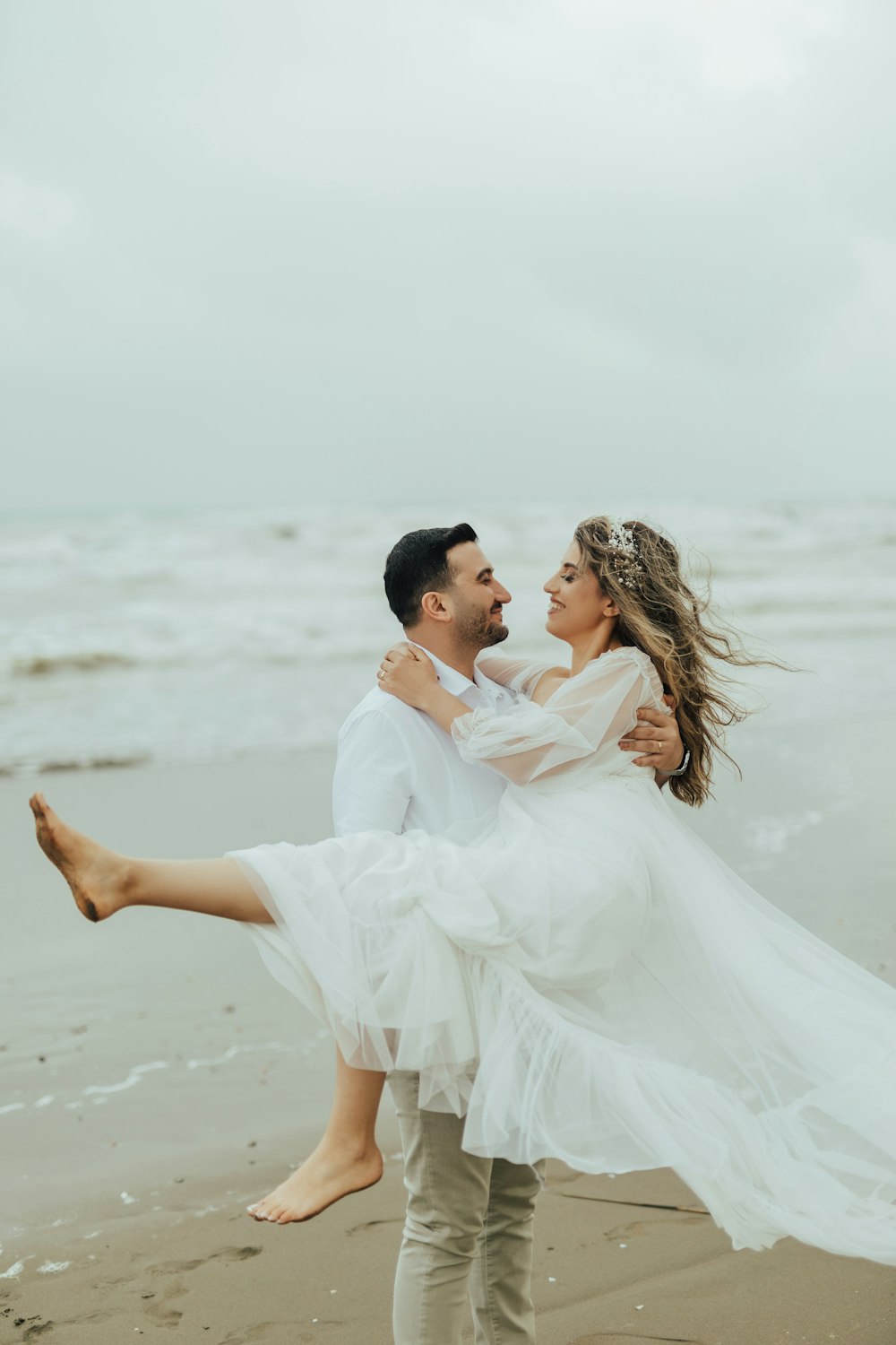 a man and woman dancing on a beach