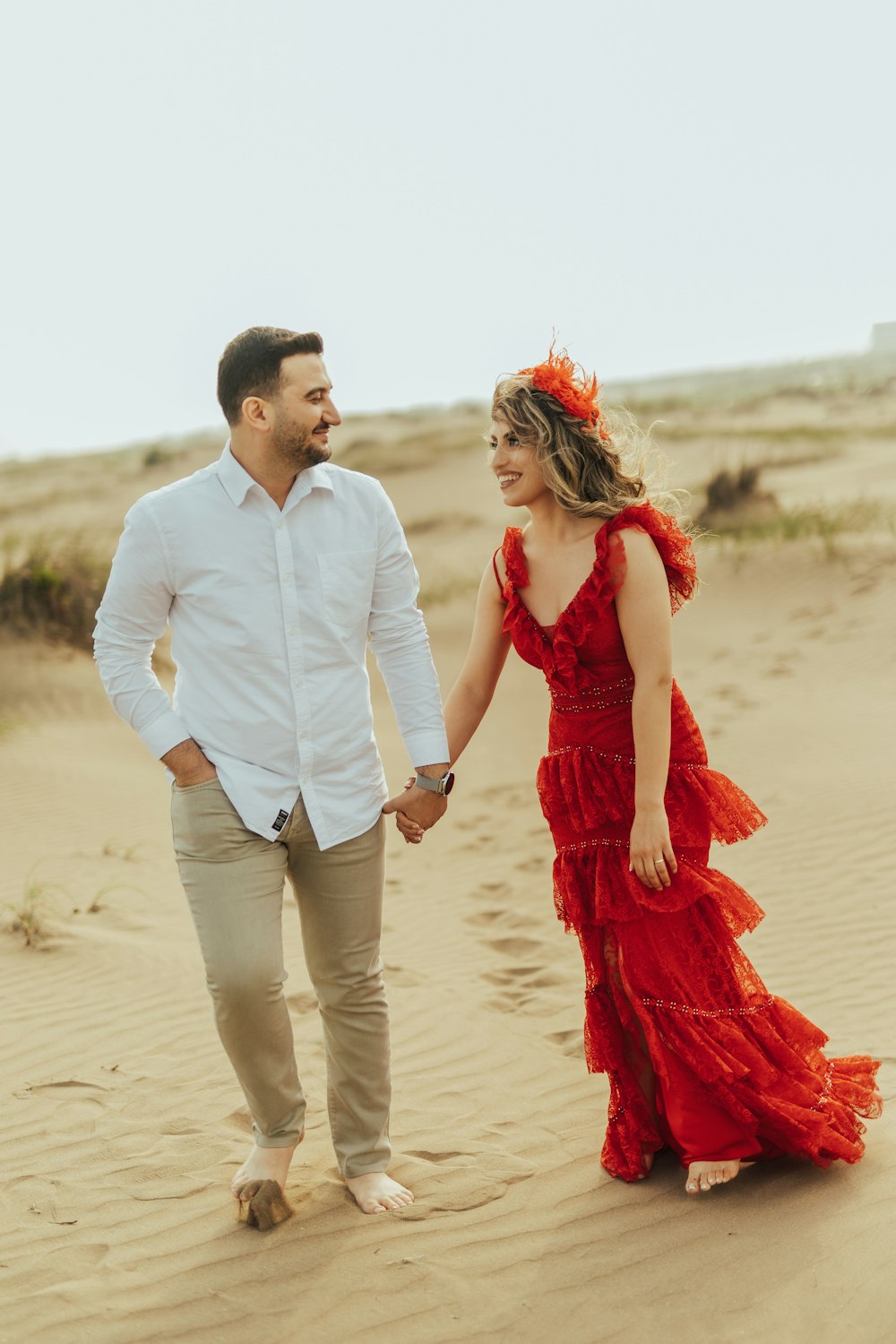 a man and woman walking on sand
