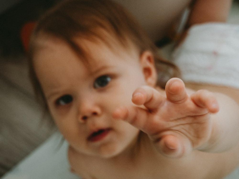 a baby with a hand on its face