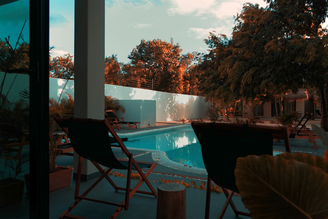 a pool with chairs around it, Chilling.