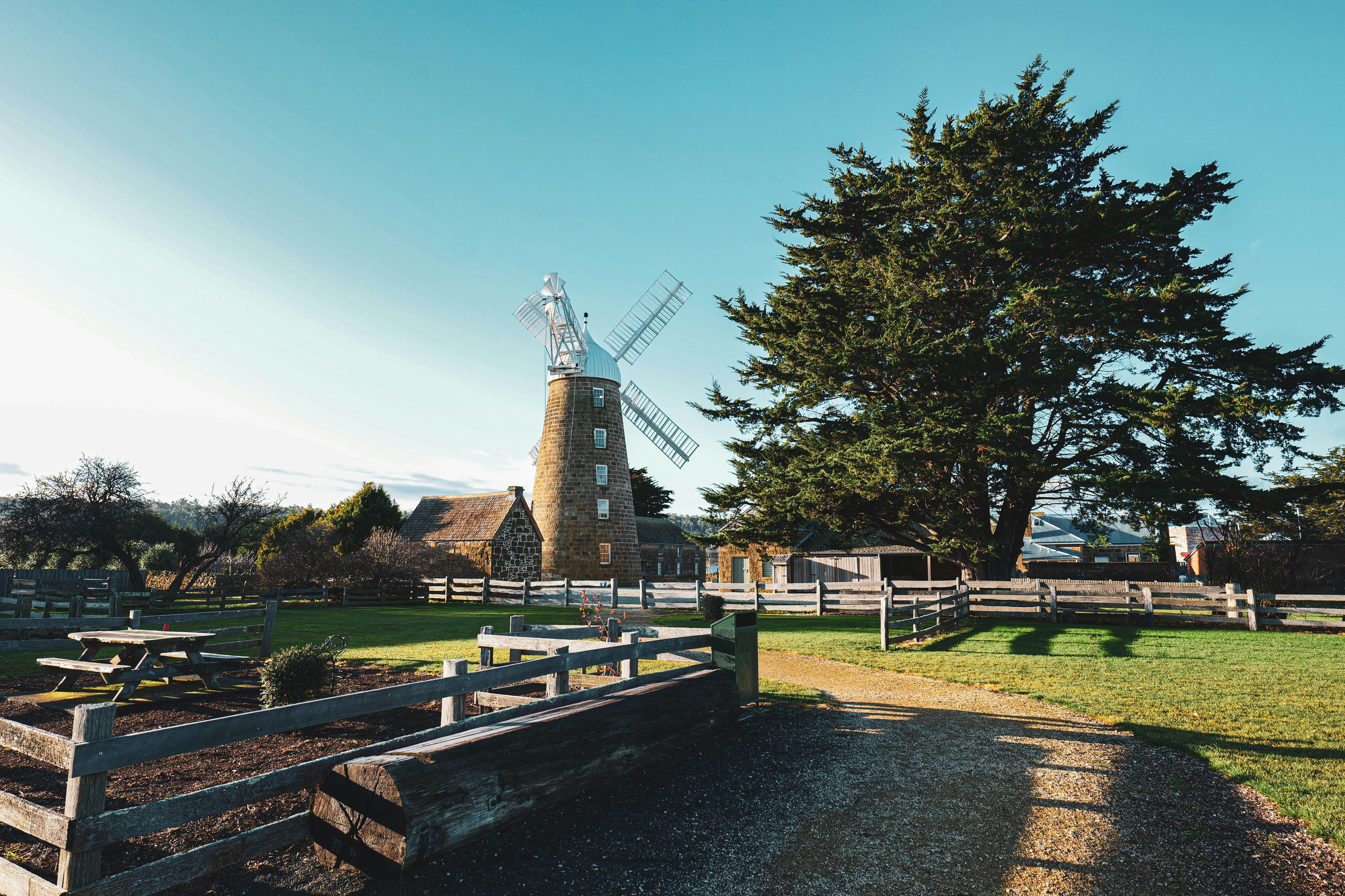 a wooden fence in front of a windmill