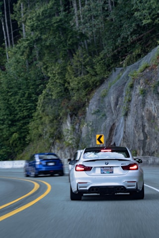 Dynamic shot of a BMW M3 speeding along a winding mountain road.