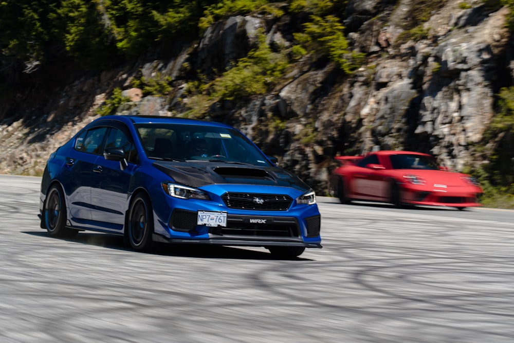 a blue car and a red car on a road