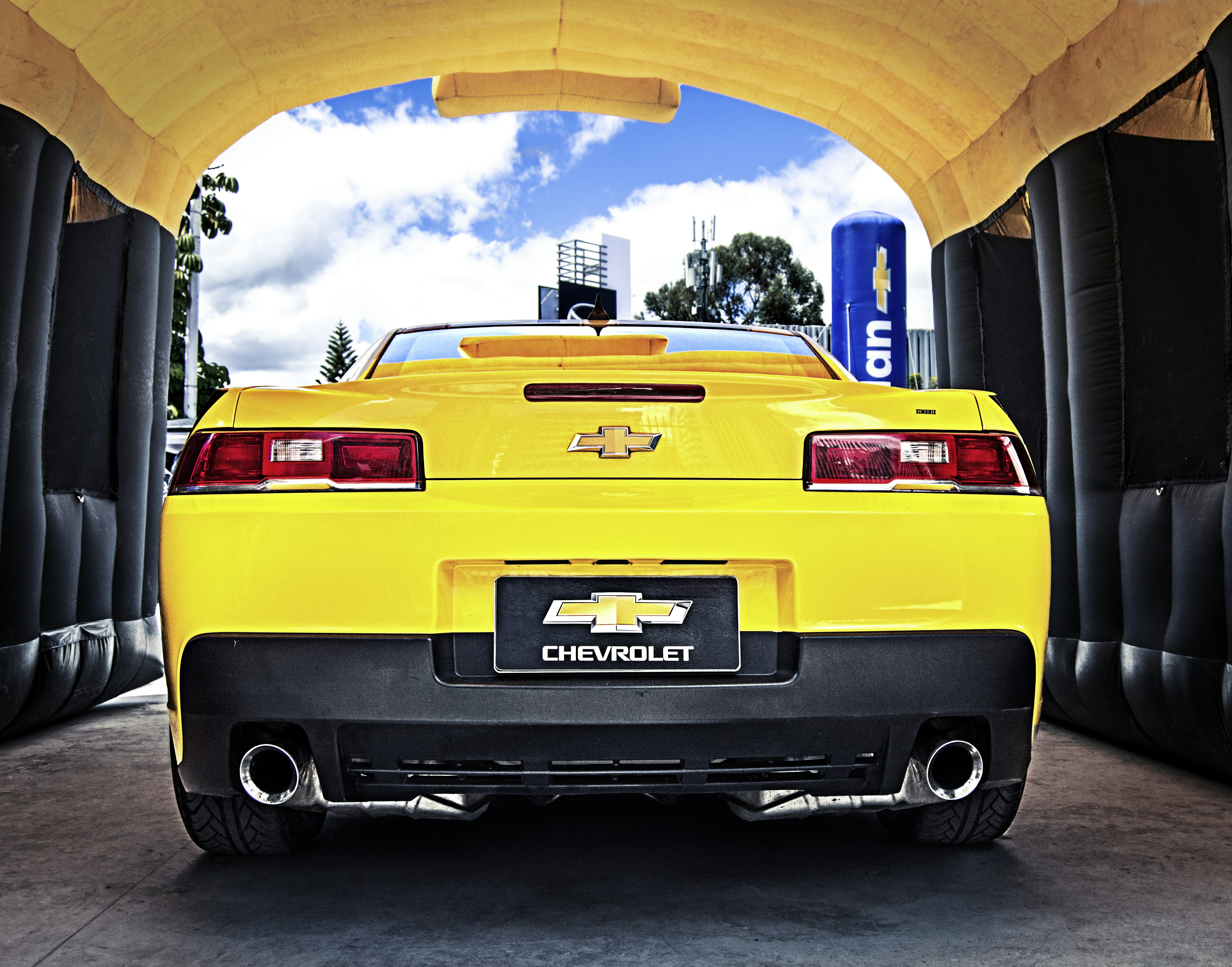 Un coche amarillo aparcado bajo una zona cubierta
