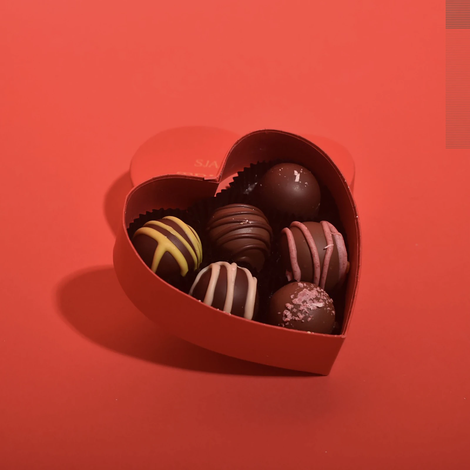 A shared bowl of chocolates on a warm table