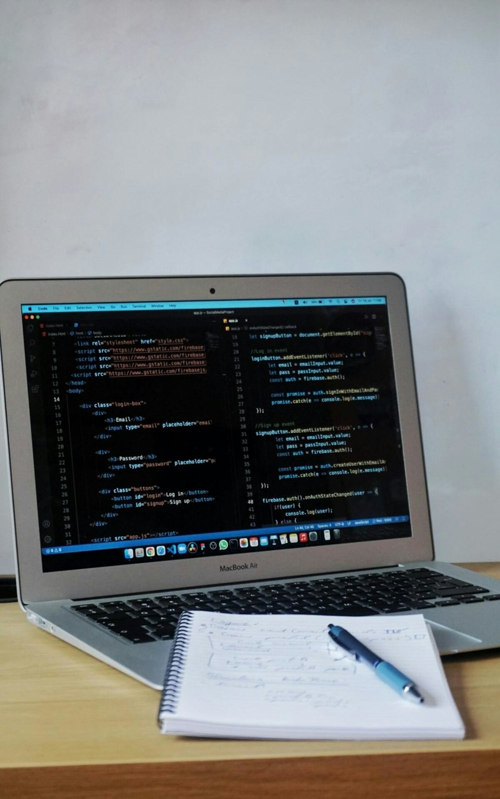 a laptop with a pen and paper on the table