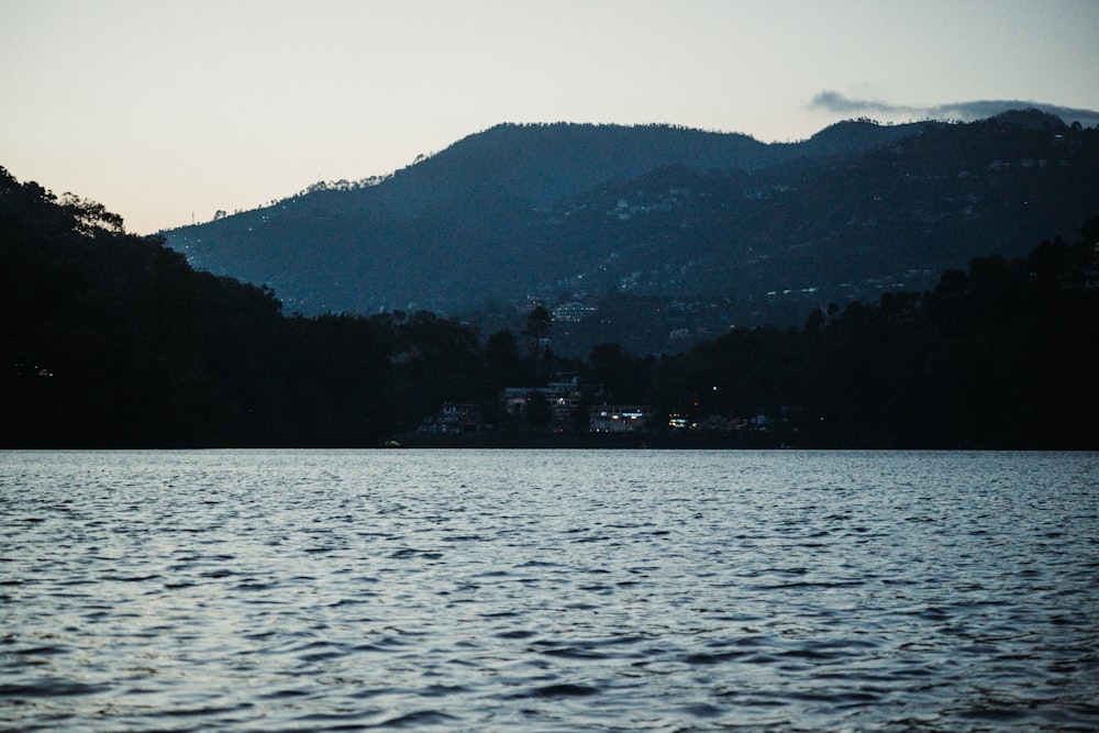 a body of water with a hill in the background