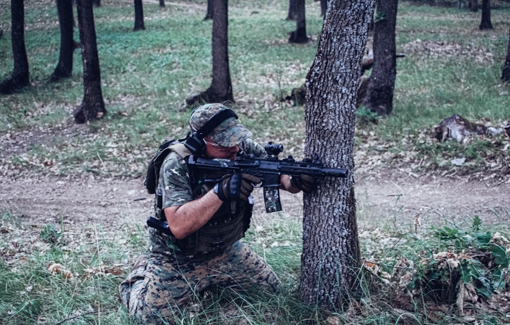 a man in camouflage aiming a gun