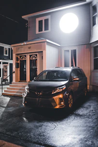 Wide driveway leading to a two-car garage with modern exterior lighting.