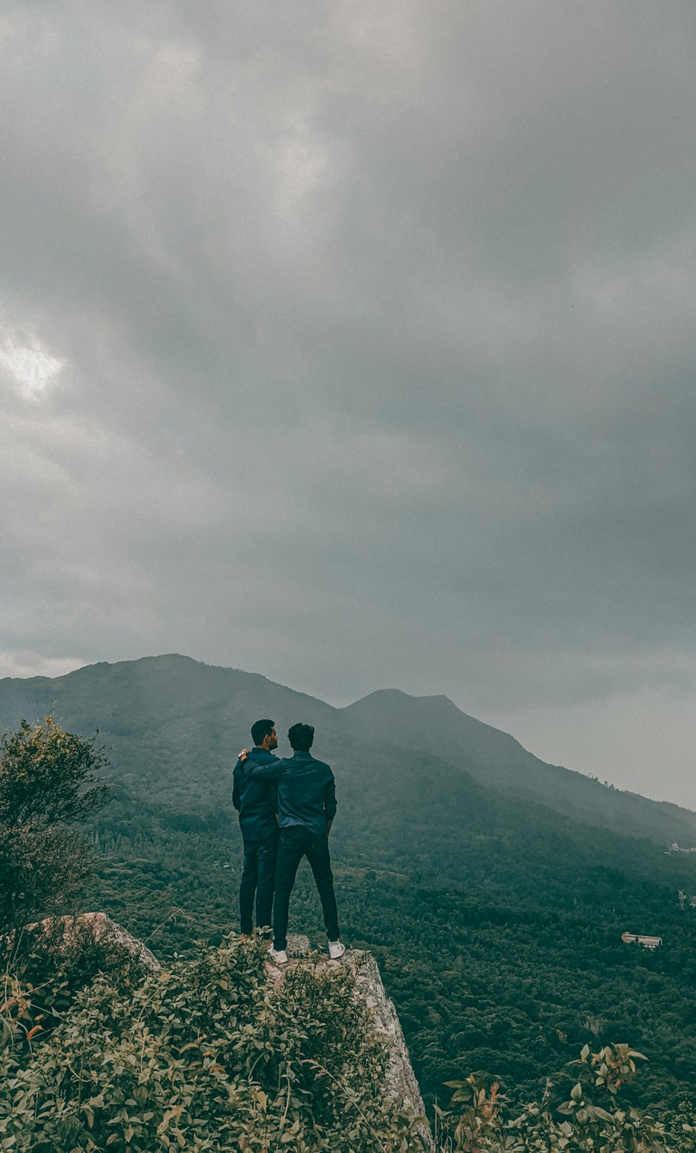 two people standing on a hill