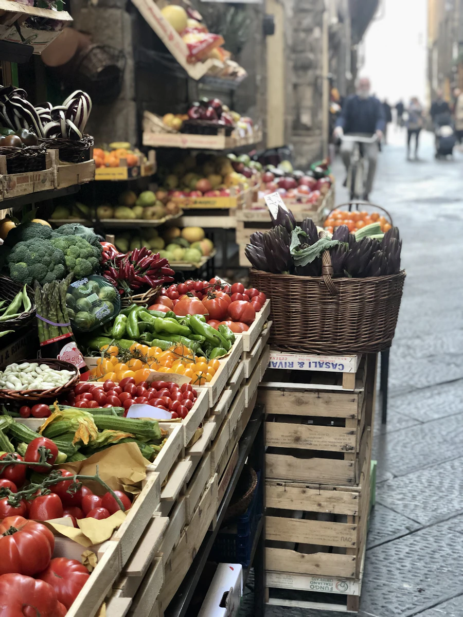 Puesto de mercado con cajas de verdura y fruta fresca
