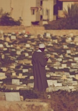 a man standing in front of a wall of bricks