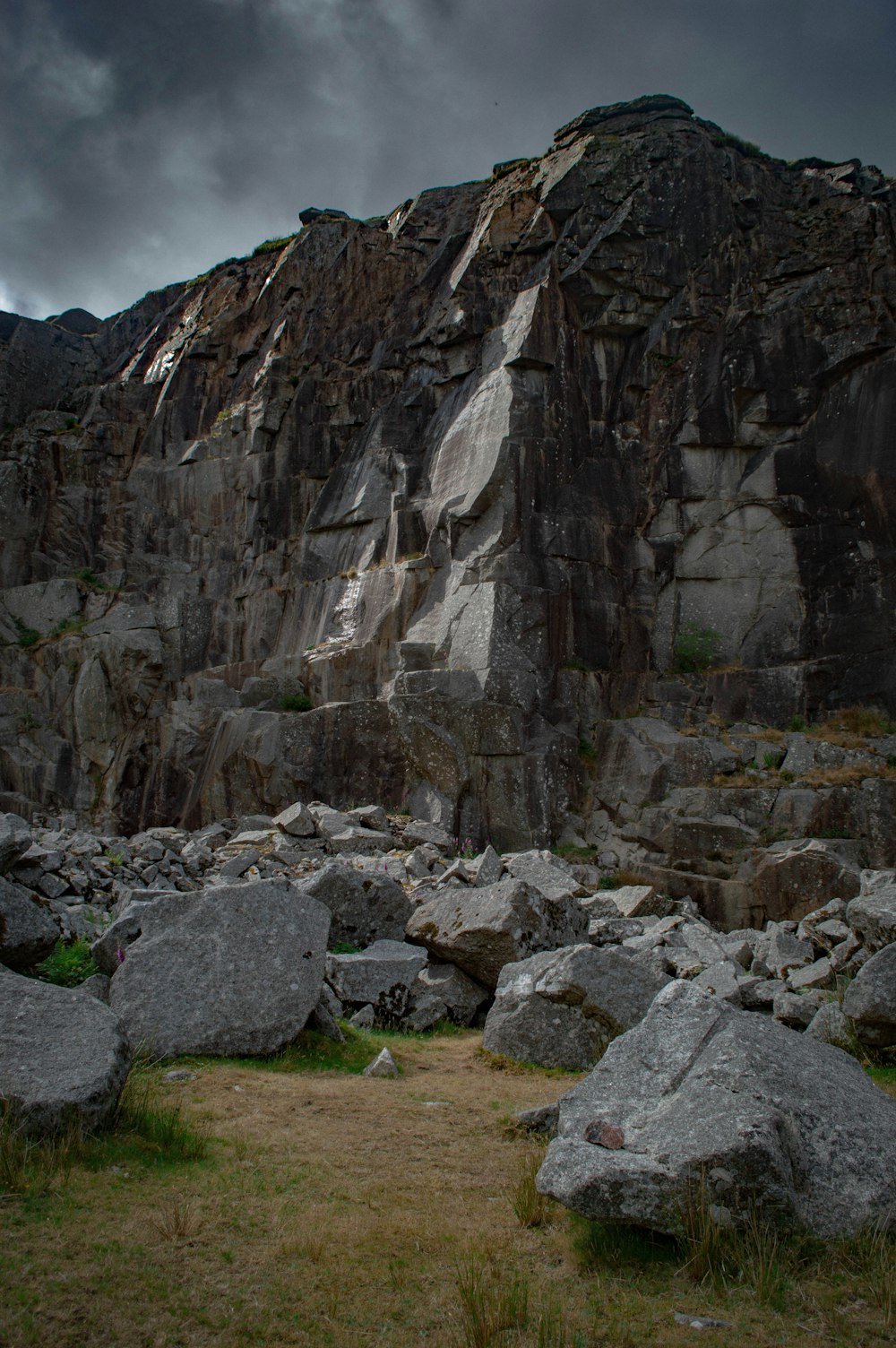 a rocky cliff with a grassy field