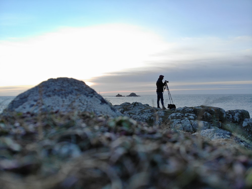 a person standing on a rocky beach
