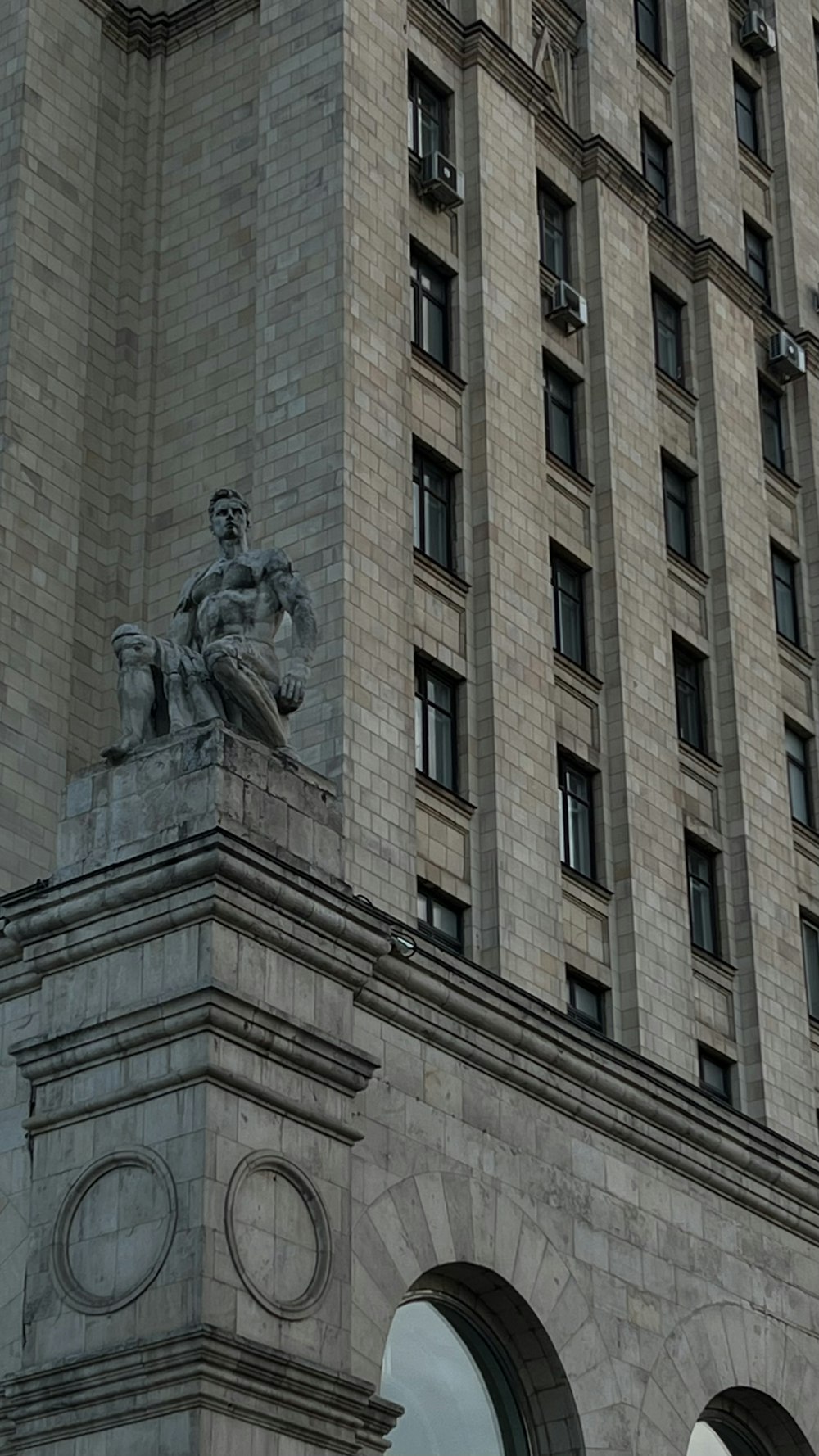 un bâtiment en pierre avec une statue sur le devant