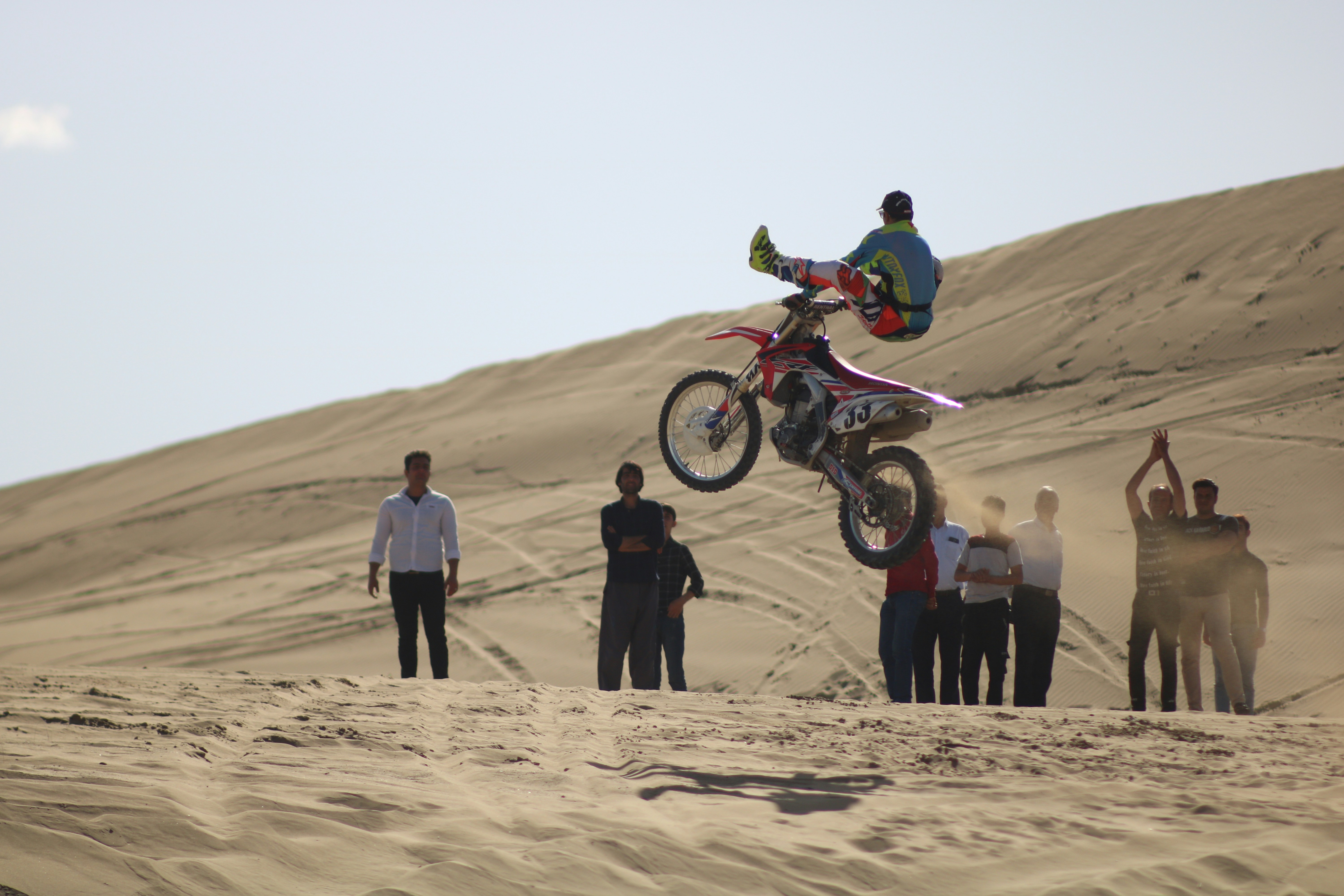 a person jumping a motorcycle over a group of people