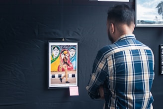 a man looking at a framed picture