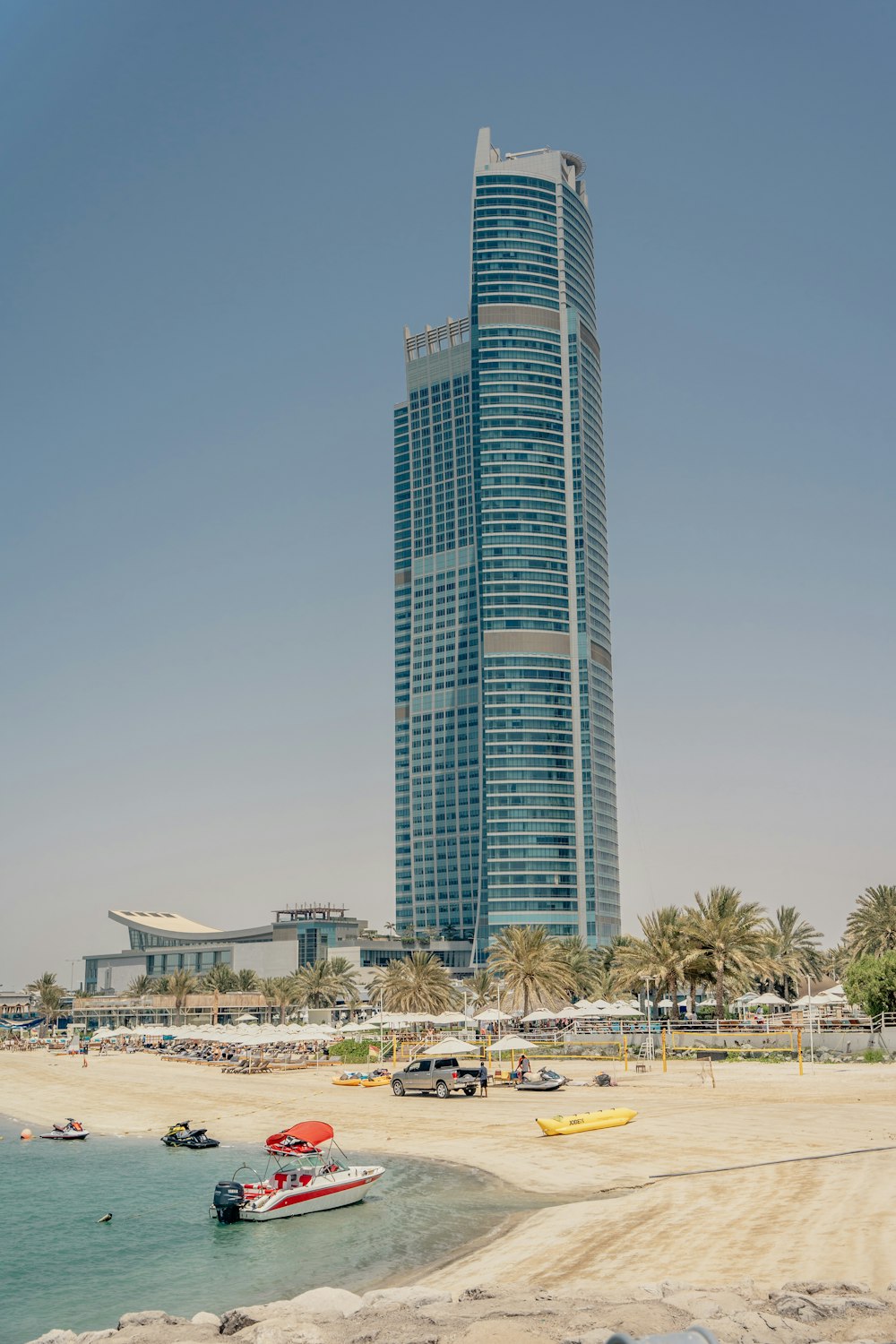 a tall glass building on a beach
