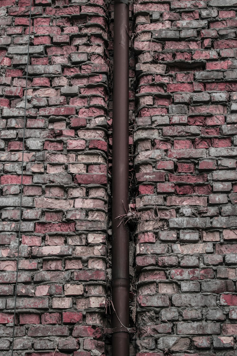 a metal pole on a brick surface