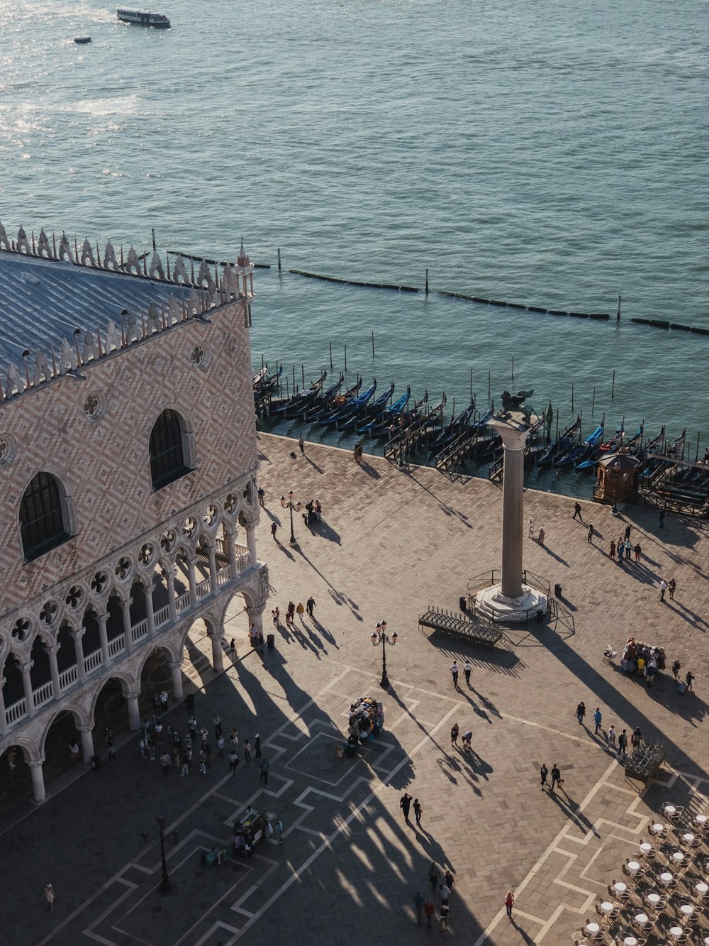 a large group of people walking along a waterfront