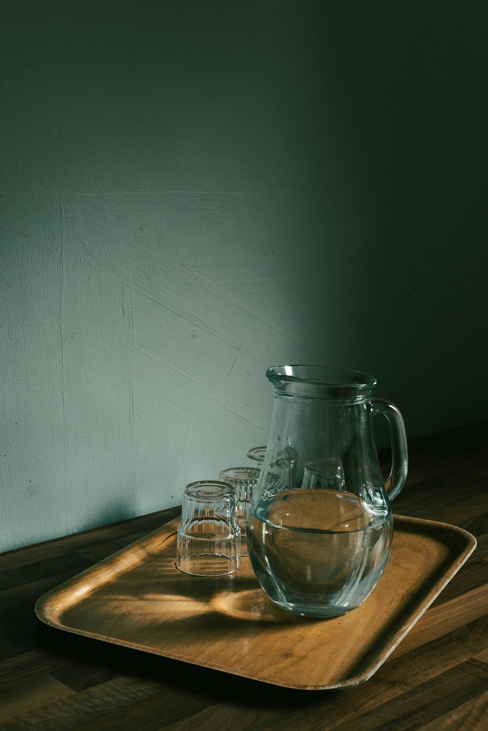 a glass pitcher and a glass pitcher on a wooden surface
