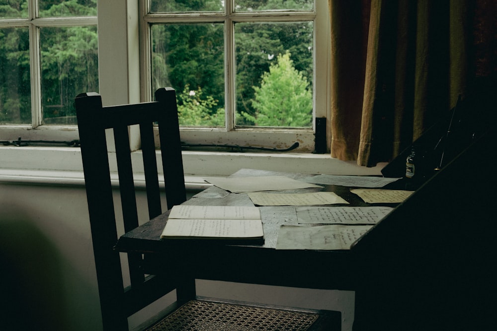 a table with a chair and papers on it