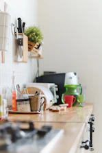 a kitchen counter with a plant and utensils