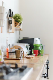 a kitchen counter with a plant and utensils