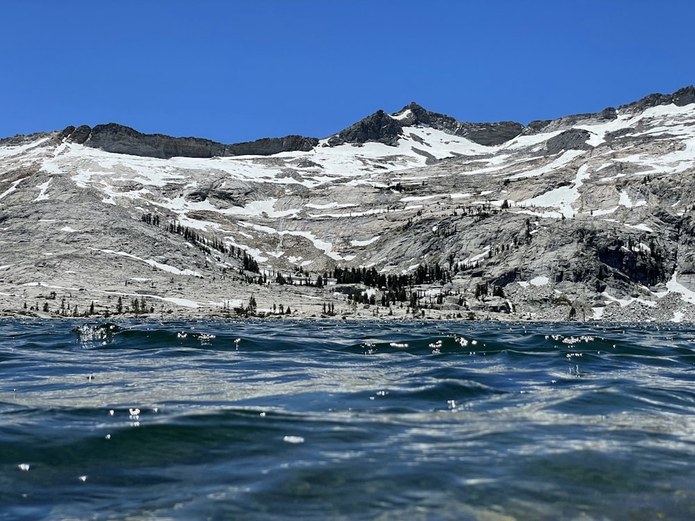 a body of water with snow covered mountains in the background