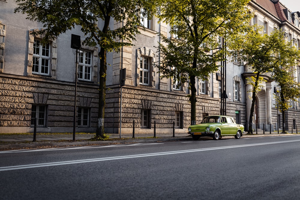 a green car parked on the side of a road