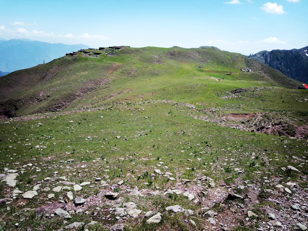 a grassy hill with rocks and grass