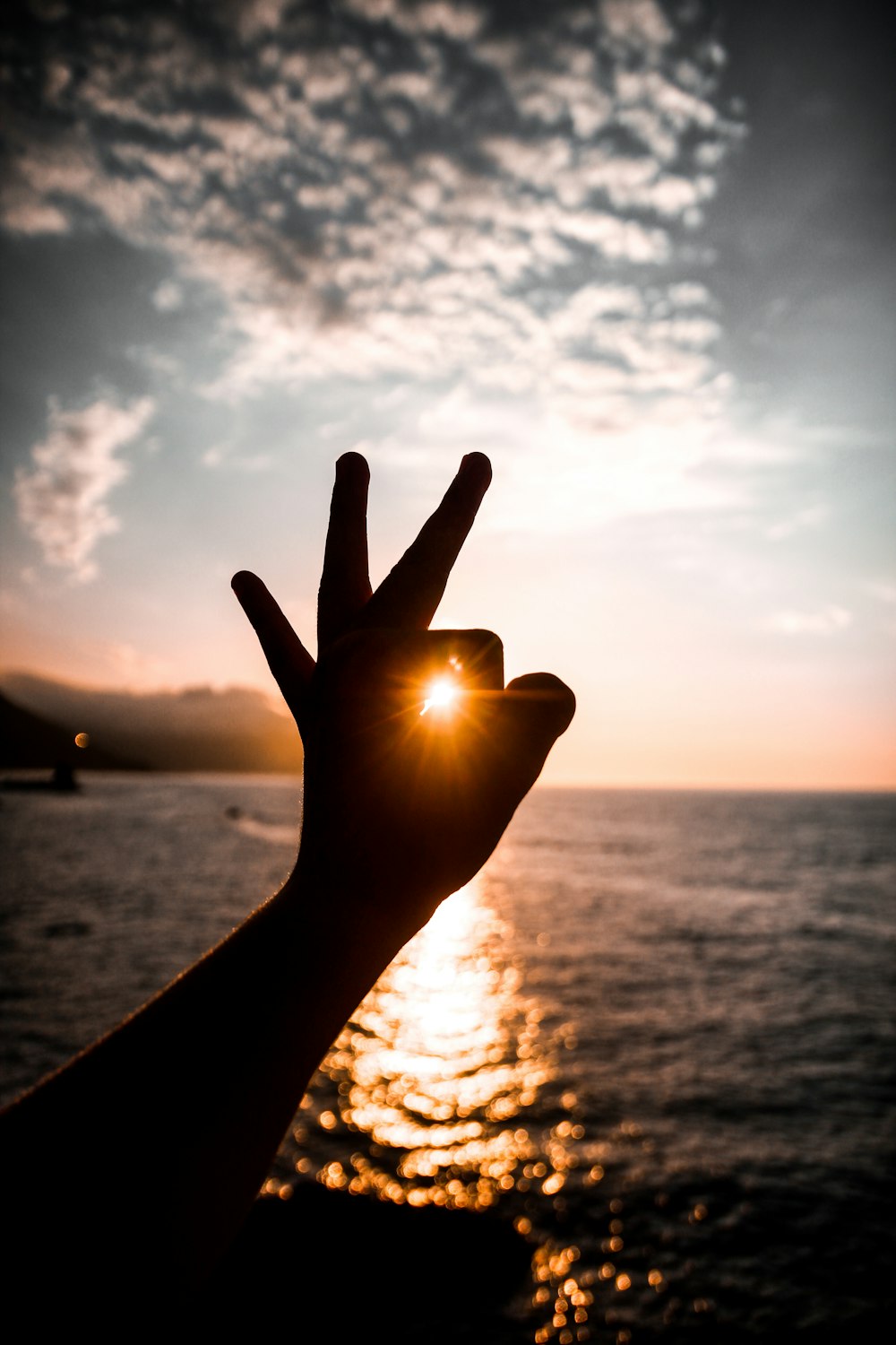 a hand with a sunset in the background