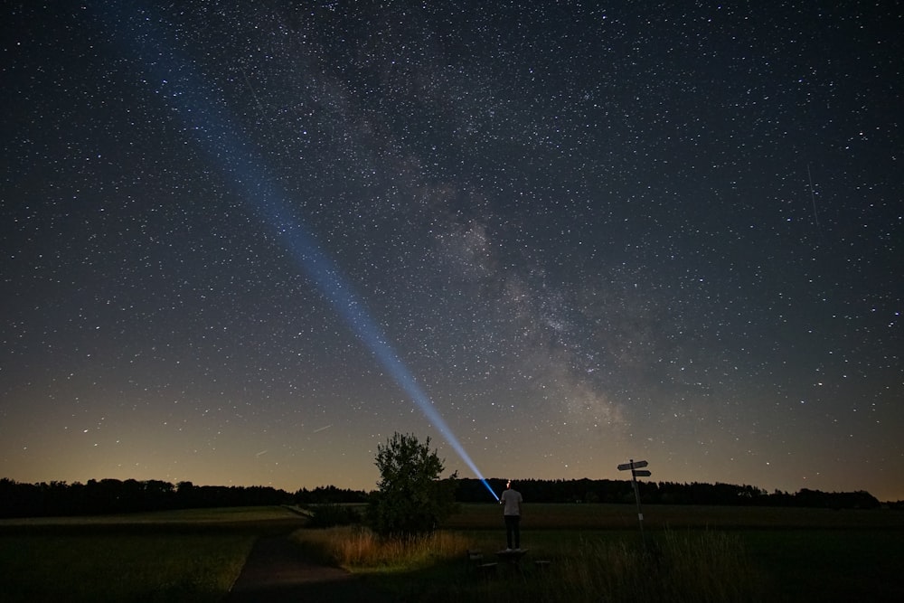 a person standing on a road with a starry sky above