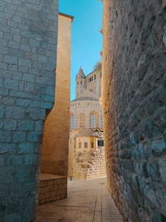 a stone walkway between two stone buildings